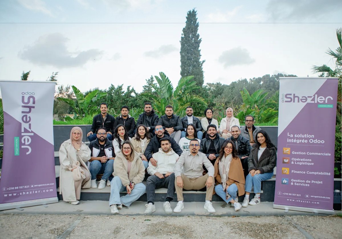L'équipe Shazler au complet, entre deux kakémonos Odoo, en Tunisie